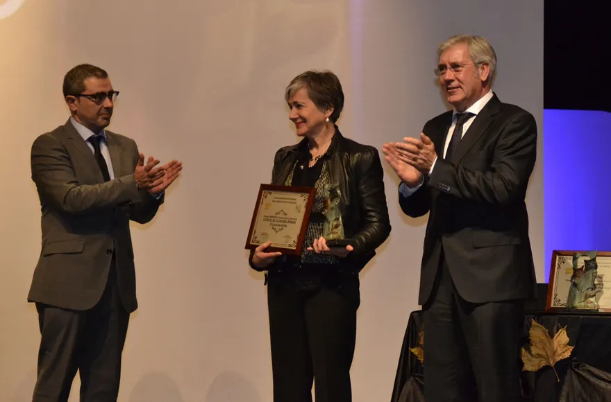 Una premiada recibe la placa entre aplausos durante la gala